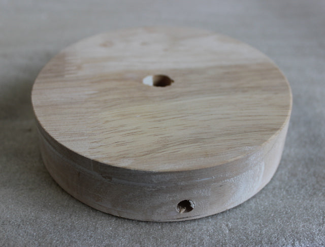 Small round wood base with straignt edges 4-1/2 inches wide.